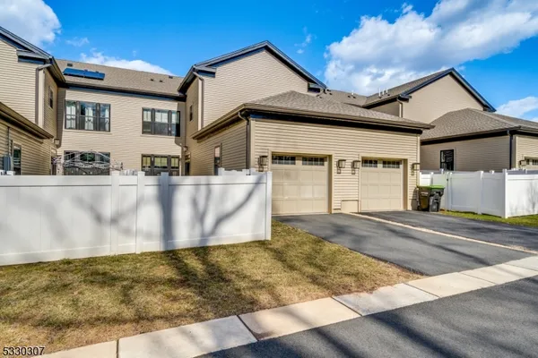 a view of a white house with large windows next to a road