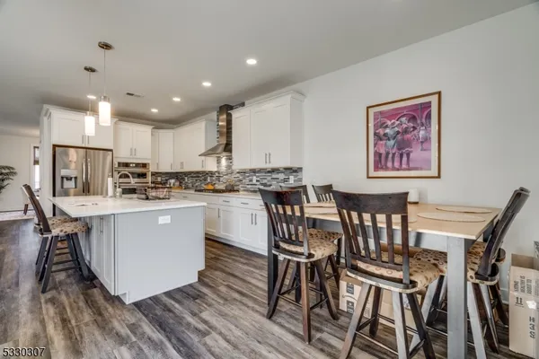 a kitchen with a table chairs a refrigerator and cabinets