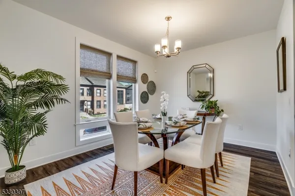 a view of a dining room with furniture a chandelier and wooden floor