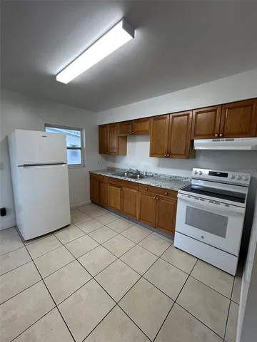 a kitchen with a cabinets and white appliances