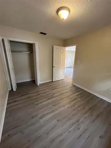 an empty room with wooden floor and closet