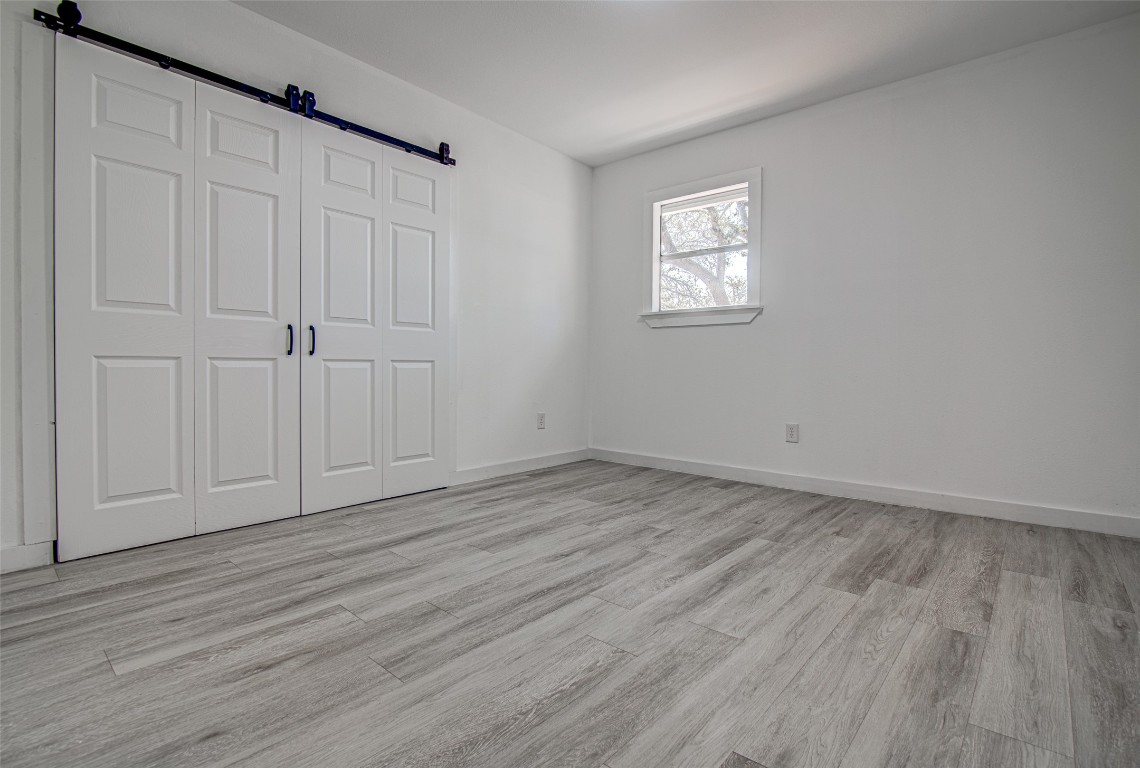 207 Haley Road Johnson City, TX 78636 - Photo 12 of 26 a view of an empty room with wooden floor and a window