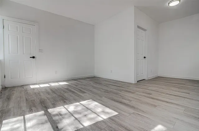 a view of empty room with wooden floor