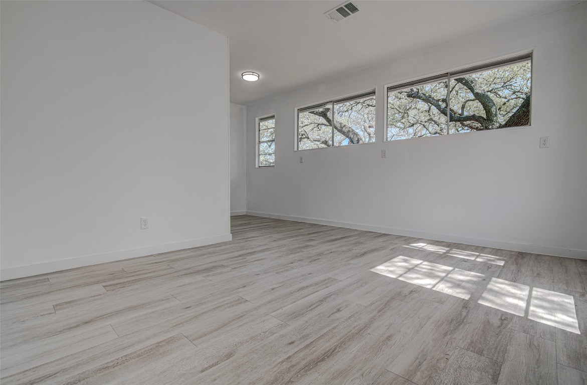 207 Haley Road Johnson City, TX 78636 - Photo 16 of 26 a view of an empty room with wooden floor and a window