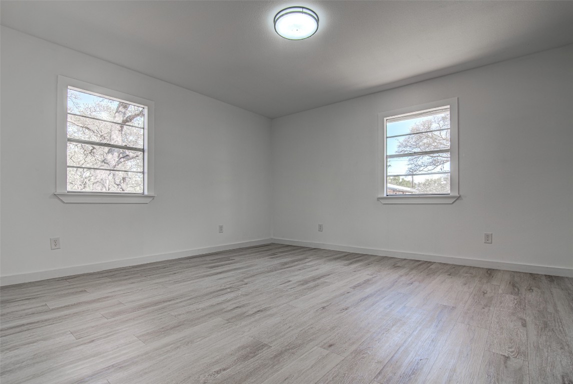 207 Haley Road Johnson City, TX 78636 - Photo 17 of 26 an empty room with wooden floor and windows