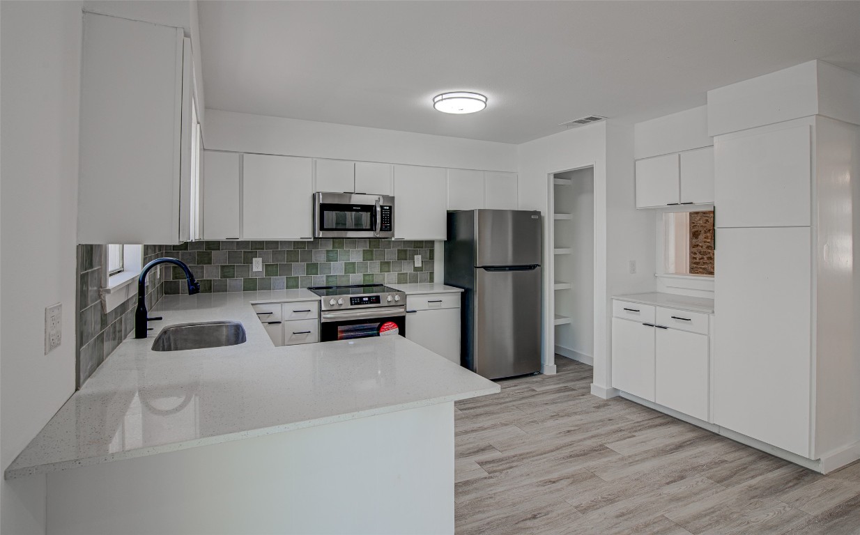 207 Haley Road Johnson City, TX 78636 - Photo 4 of 26 a kitchen with a refrigerator a stove top oven a sink and cabinets