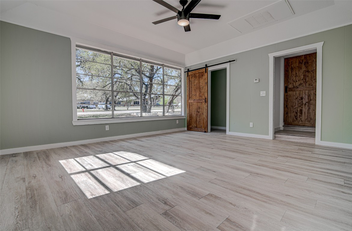207 Haley Road Johnson City, TX 78636 - Photo 7 of 26 an empty room with wooden floor and windows