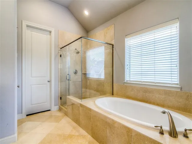 a spacious bathroom with a tub shower and a sink
