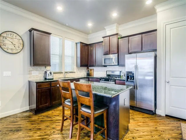 a kitchen with stainless steel appliances granite countertop a stove refrigerator sink and dishwasher