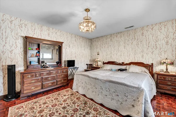 a bedroom with a bed and a dresser in it