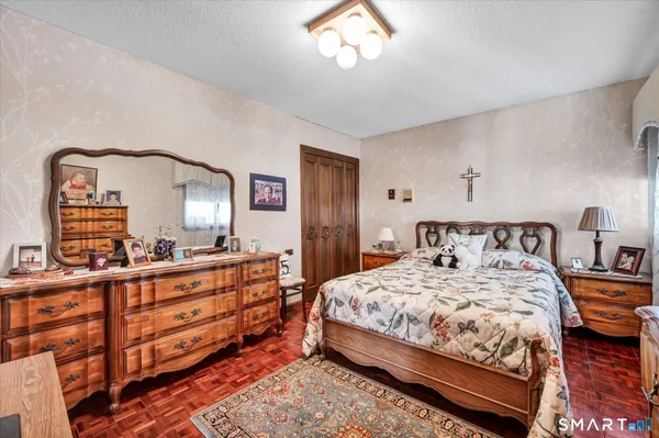 a bedroom with a bed and wooden floor