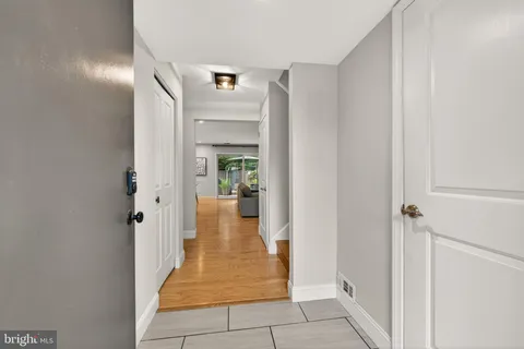 a view of a hallway with wooden cabinets