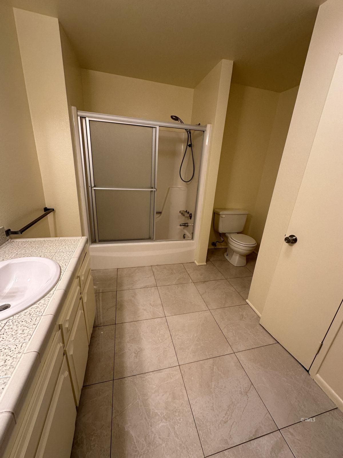 263 East Line Street, Unit F Bishop, CA 93514 - Photo 11 of 13 a bathroom with a granite countertop sink toilet and shower