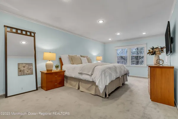 a spacious bedroom with a bed and a flat screen television