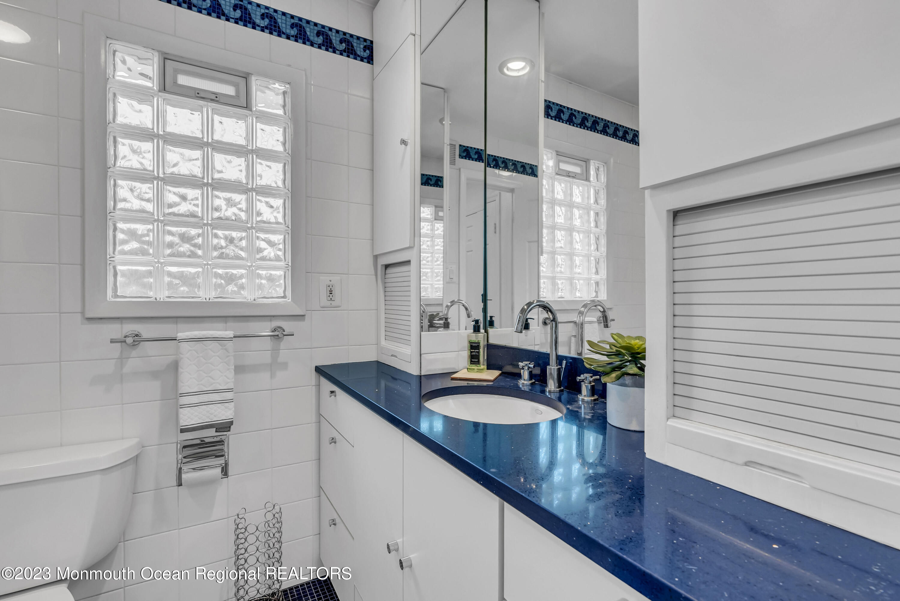 2912 Logan Road Asbury Park, NJ 07712 - Photo 21 of 30 a bathroom with a granite countertop sink a toilet a mirror and shower