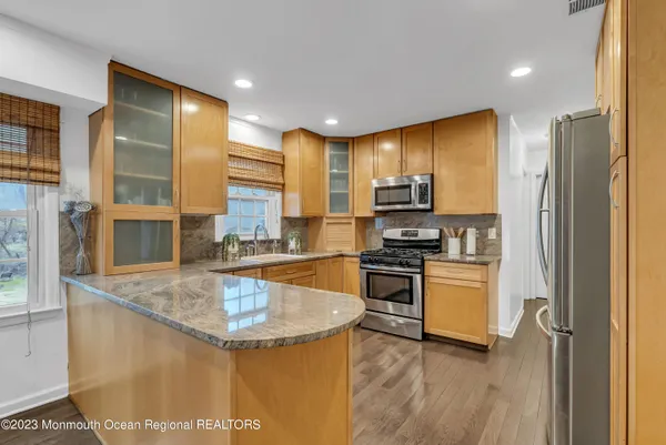 a kitchen with stainless steel appliances granite countertop a sink stove and refrigerator