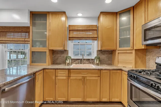 a kitchen with stainless steel appliances granite countertop a stove a sink and a microwave