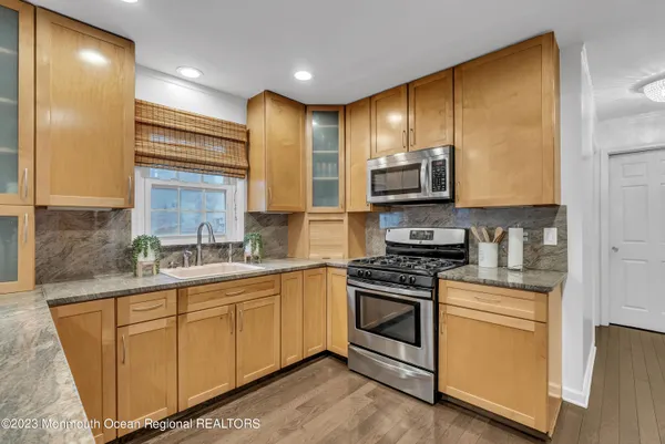 a kitchen with stainless steel appliances granite countertop a stove a sink and a microwave