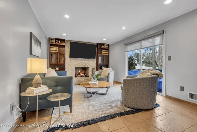 a living room with furniture a fireplace and a large window