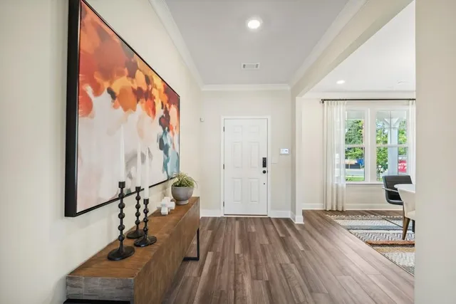 a view of hallway with a large window and wooden floor