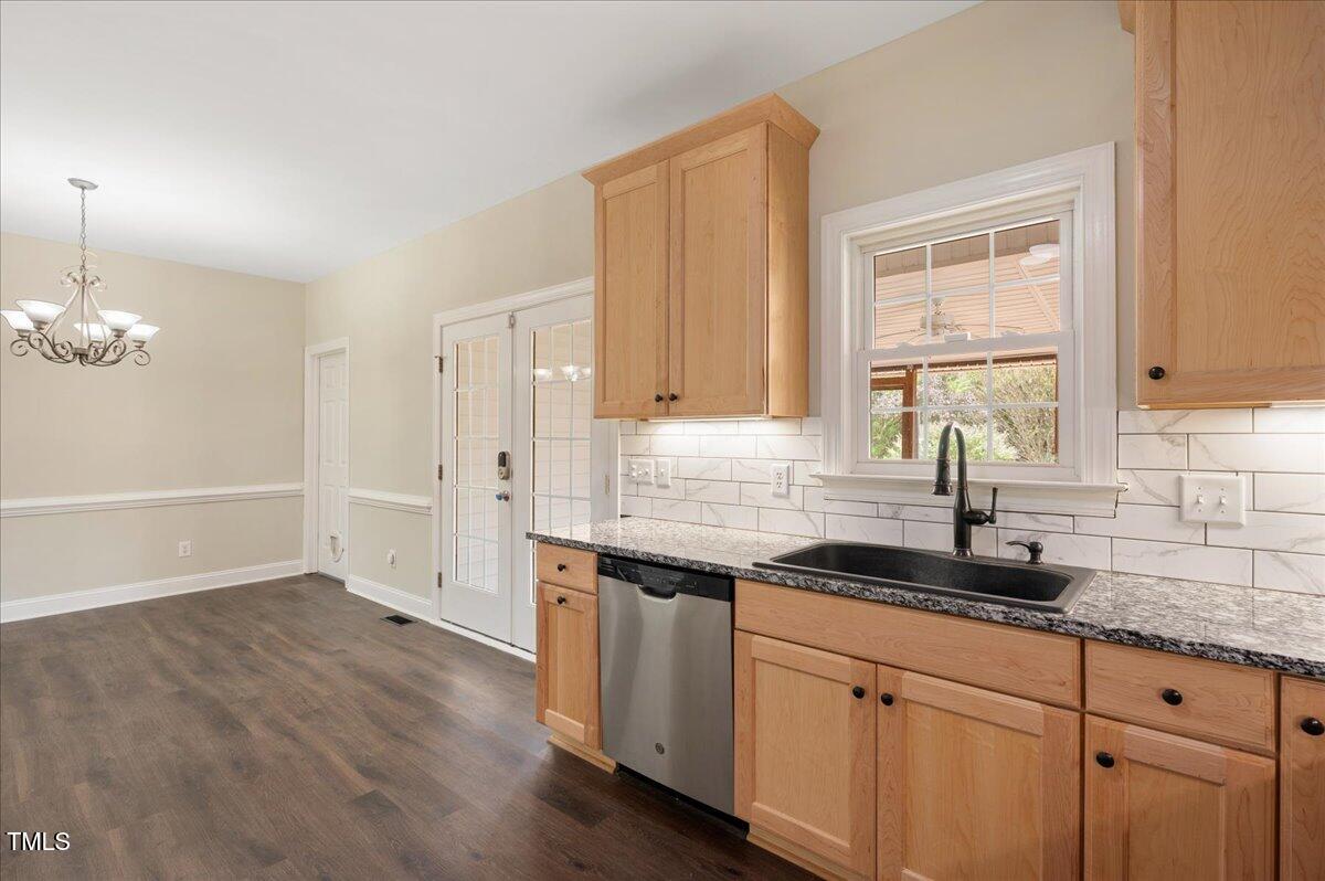 7805 Tuscan Ridge Drive Wendell, NC 27591 - Photo 12 of 40 a kitchen with granite countertop white cabinets white appliances a sink and a window