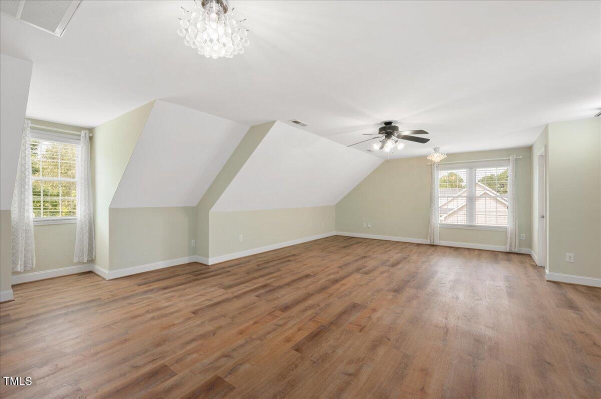 7805 Tuscan Ridge Drive Wendell, NC 27591 - Photo 22 of 40 an empty room with wooden floor chandelier and windows