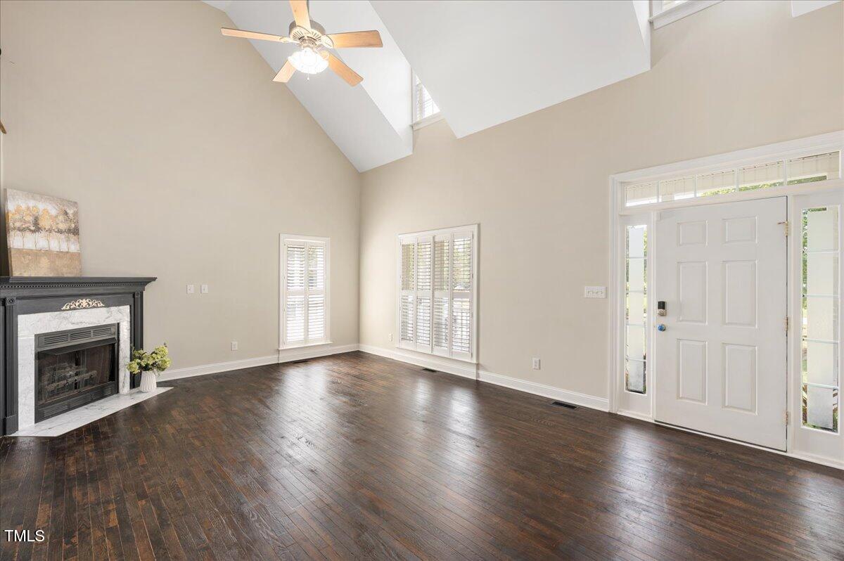 7805 Tuscan Ridge Drive Wendell, NC 27591 - Photo 5 of 40 an empty room with wooden floor fireplace and windows