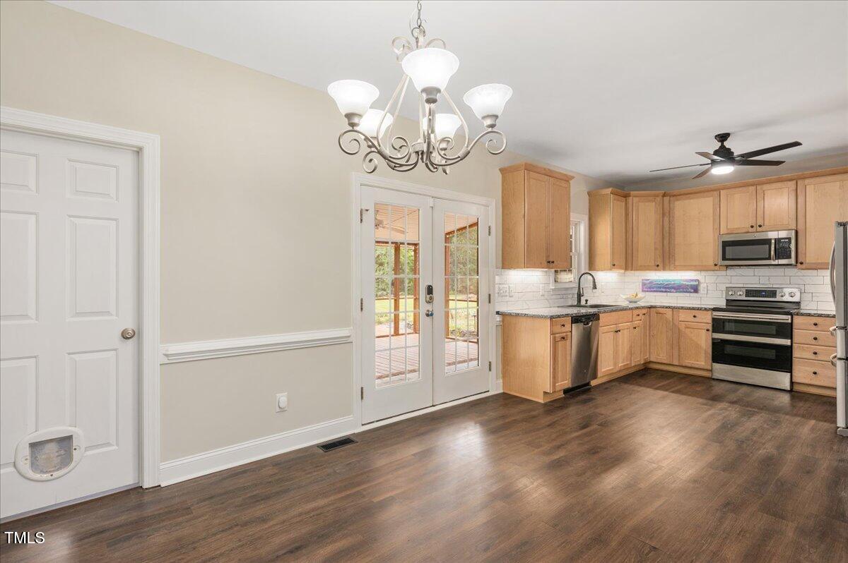 7805 Tuscan Ridge Drive Wendell, NC 27591 - Photo 9 of 40 a kitchen with stainless steel appliances granite countertop a stove cabinets and wooden floor