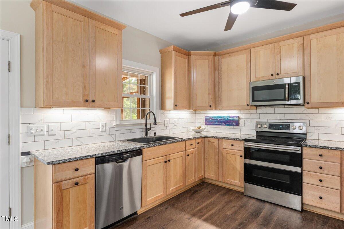 7805 Tuscan Ridge Drive Wendell, NC 27591 - Photo 10 of 40 a kitchen with stainless steel appliances granite countertop a stove sink microwave and cabinets