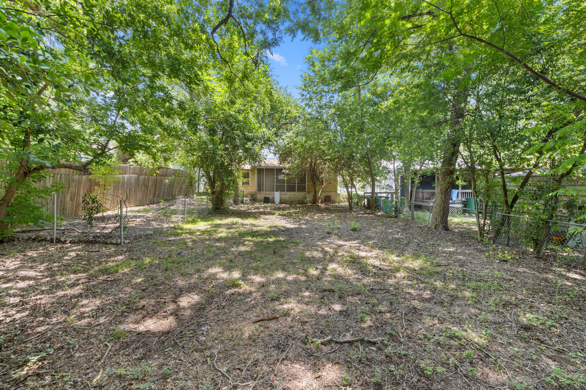 3704 Cherrywood Road Austin, TX 78722 - Photo 36 of 40 Mature trees canopy this sizable, fenced backyard, offering both privacy and abundant green space for recreation.