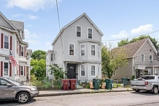 a front view of a house with a garden and parking