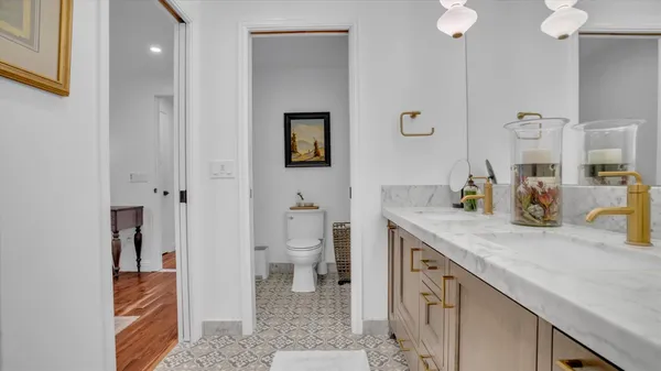 a spacious bathroom with a granite countertop sink and a toilet