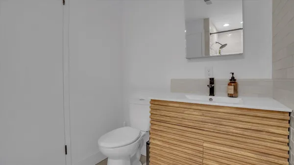 a bathroom with a sink a toilet and mirror