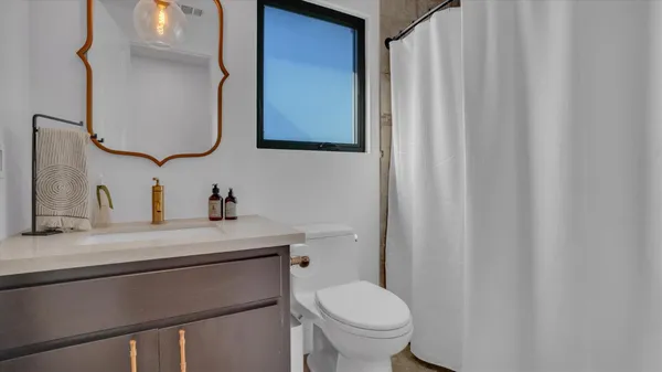 a bathroom with a sink a toilet and mirror