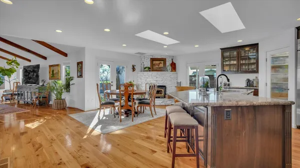 a dining hall with stainless steel appliances granite countertop a dining table and chairs with wooden floor