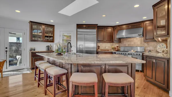 a kitchen with a dining table chairs cabinets and stainless steel appliances