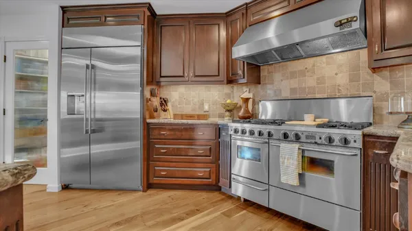 a kitchen with stainless steel appliances granite countertop a stove and a refrigerator