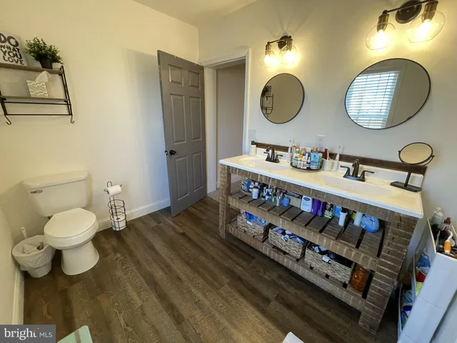 a bathroom with a toilet sink mirror and vanity
