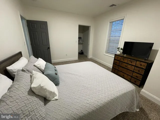 a bedroom with a bed and flat screen tv