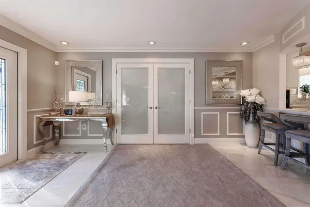 a large bed sitting in a bedroom next to a cabinet with glass door