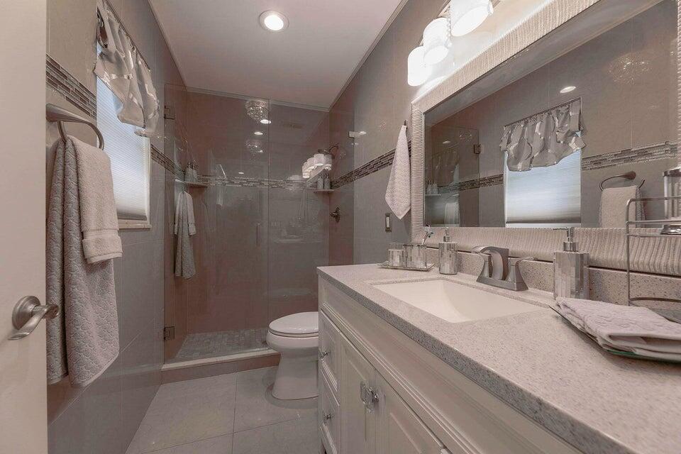 2935 Lake Worth Road Palm Springs, FL 33461 - Photo 14 of 22 a bathroom with a double vanity sink toilet and shower
