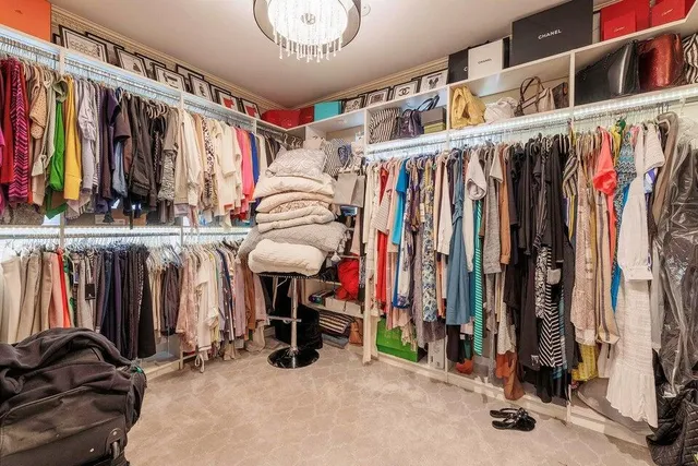 a view of walk in closet with clothes and shoes