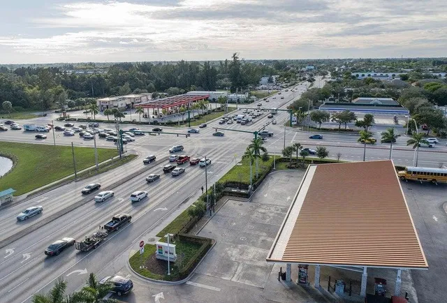 a living room with furniture a flat screen tv and kitchen view