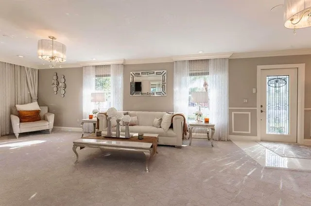 a dining room filled chandelier and kitchen view