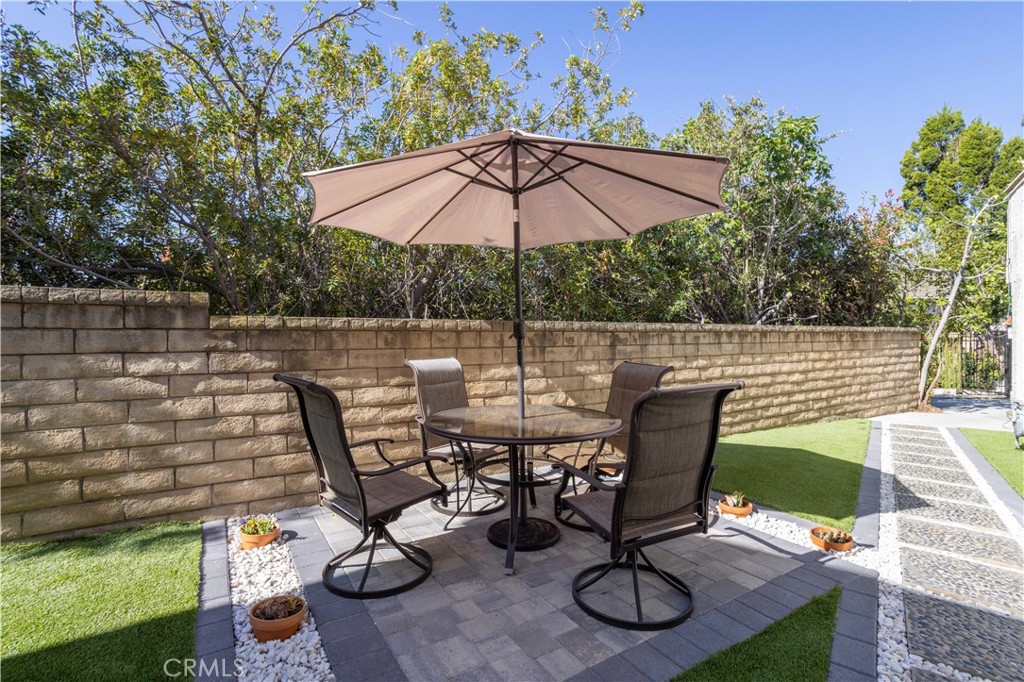 19429 Singing Hills Drive Porter Ranch, CA 91326 - Photo 25 of 26 a view of a patio with table and chairs under an umbrella