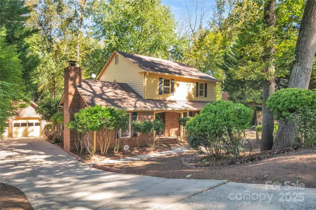 a view of a house with a tree in front of it