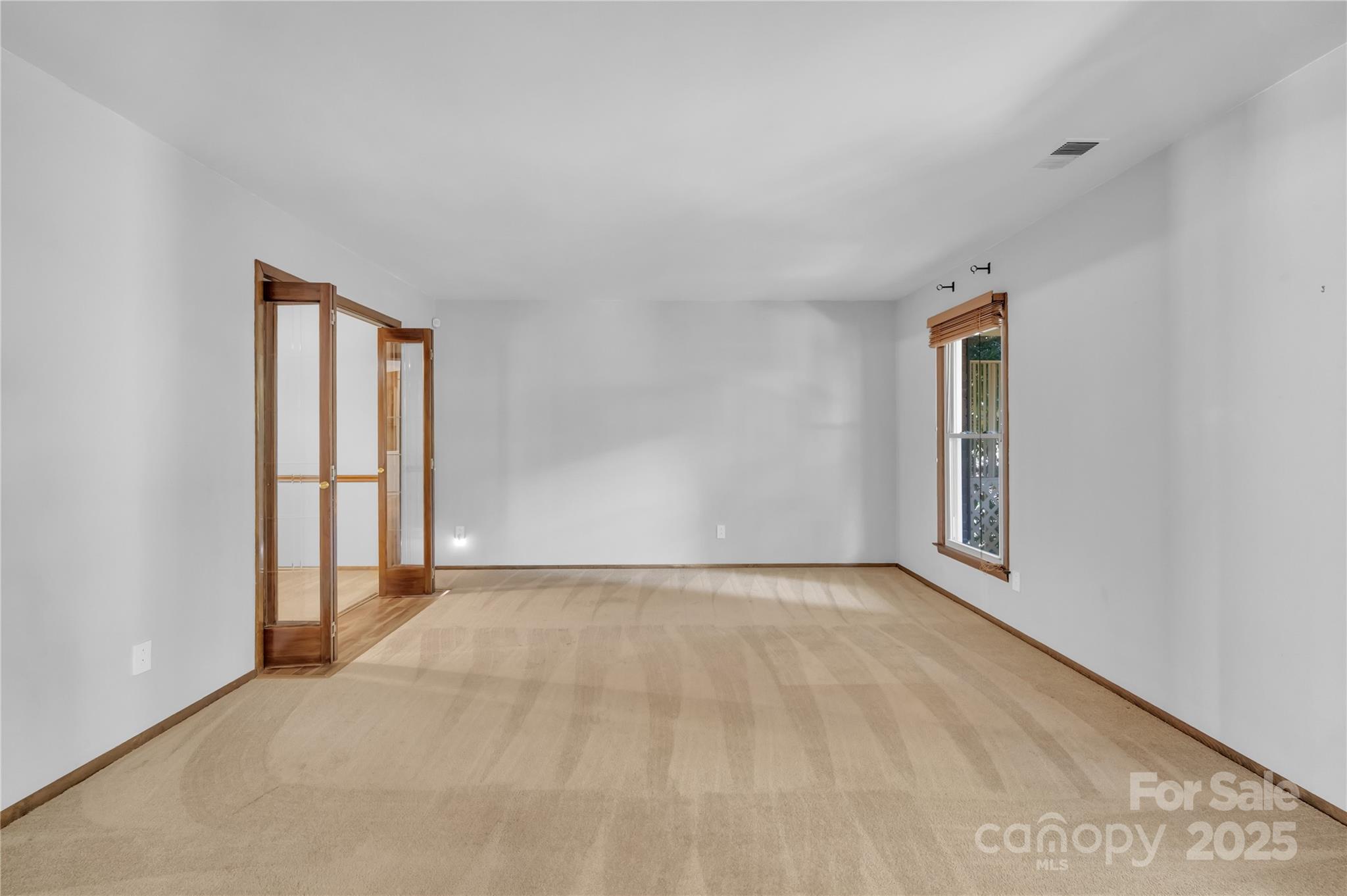 702 Trail Ridge Road Matthews, NC 28105 - Photo 11 of 36 a view of an empty room with window and wooden floor