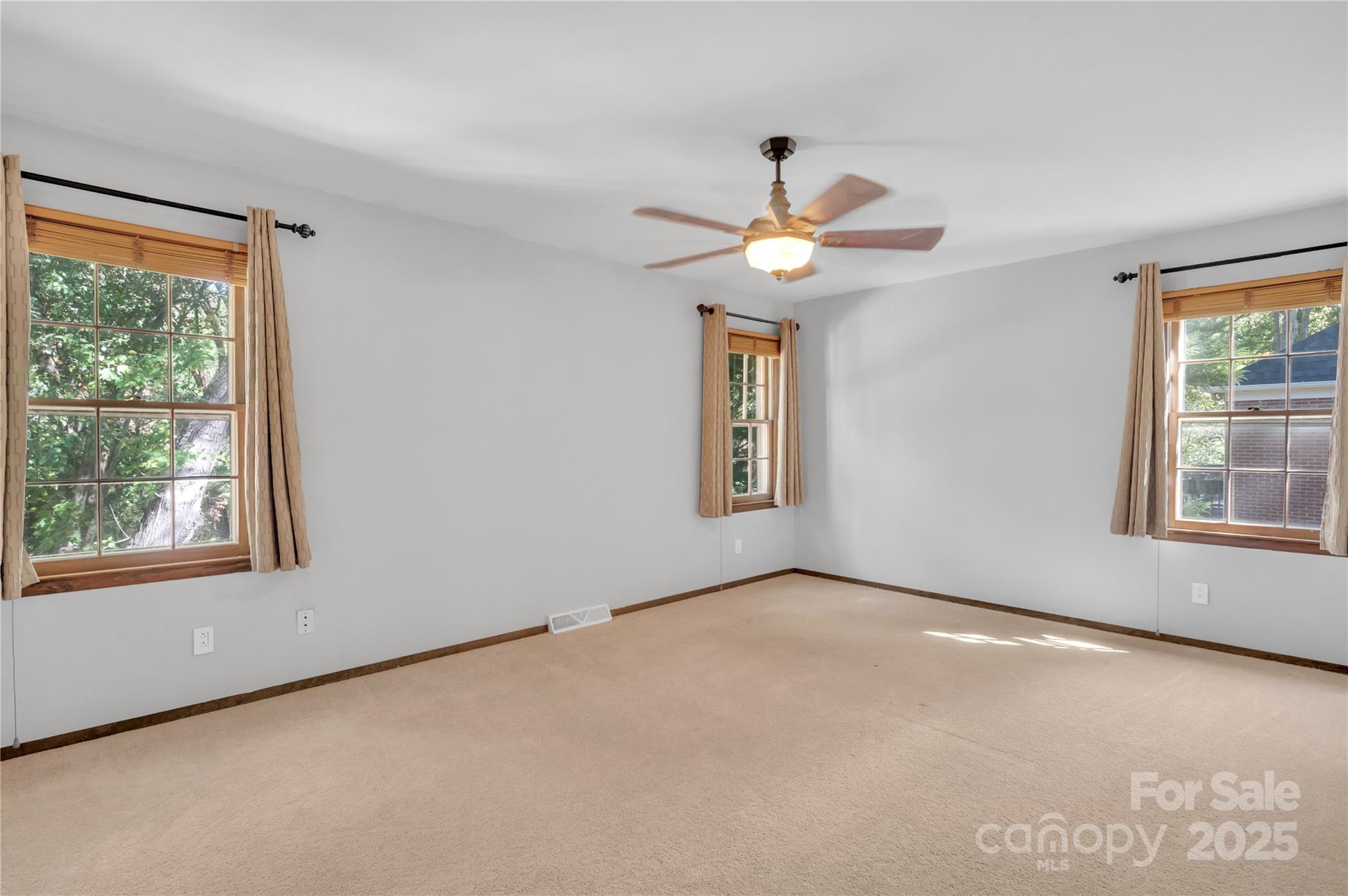 702 Trail Ridge Road Matthews, NC 28105 - Photo 15 of 36 an empty room with windows and chandelier fan