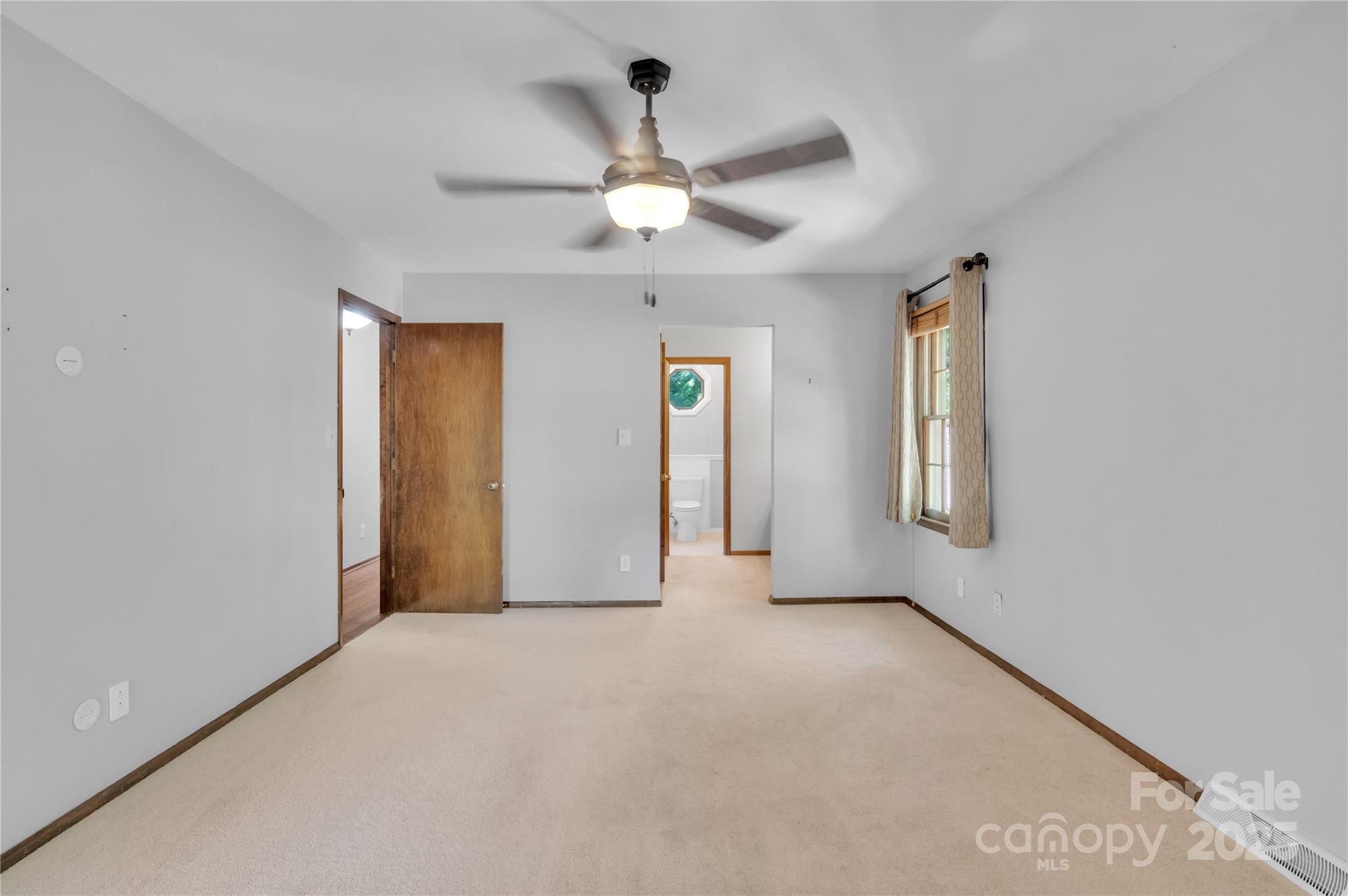 702 Trail Ridge Road Matthews, NC 28105 - Photo 16 of 36 an empty room with chandelier fan and windows