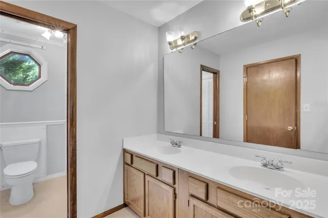 a bathroom with a sink a toilet and a mirror